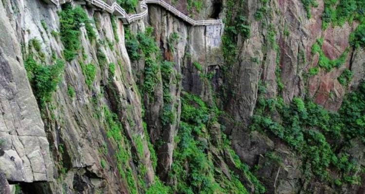 Smal pad langs steile kliffen omgeven door groen.