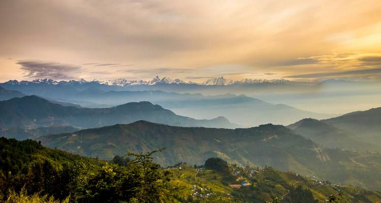 Vue panoramique de chaînes de montagnes avec un ciel de coucher de soleil.