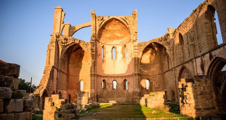 Ruins of a Gothic-style church bathed in golden light.