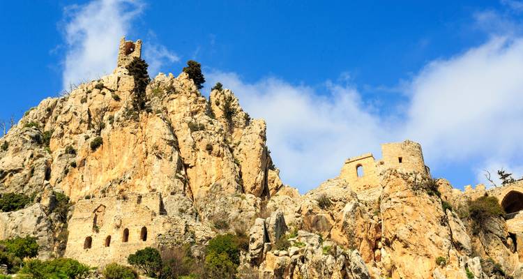 Ruins of a castle built into a rocky mountain.