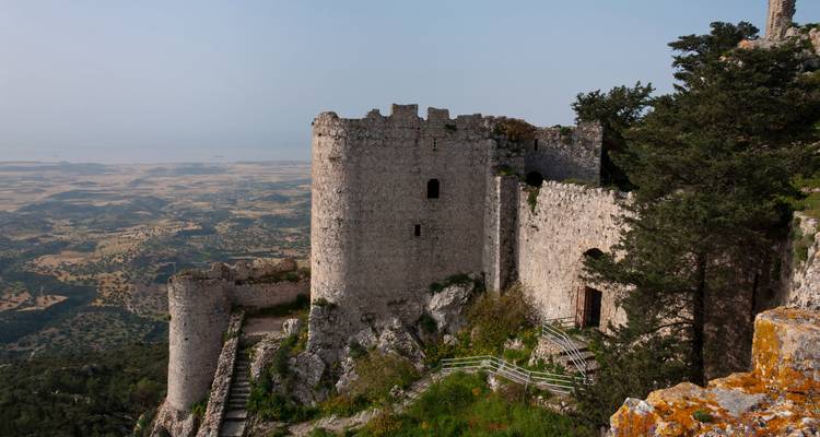 A medieval castle on a hilltop with a scenic view.