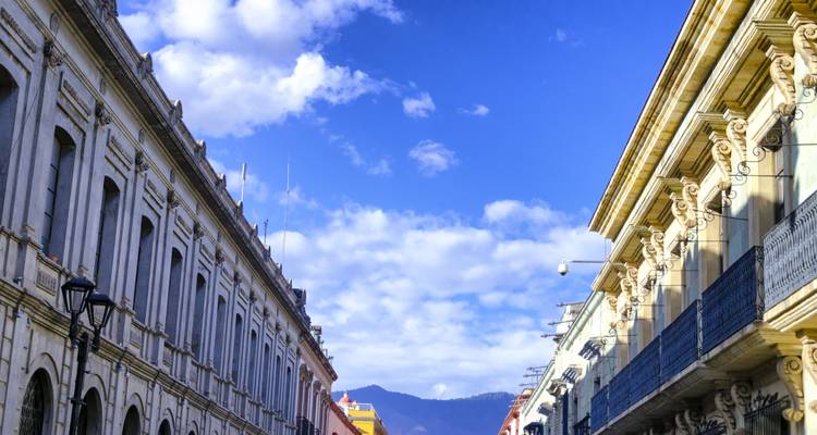 Vista de calle con edificios tradicionales bajo un cielo azul.