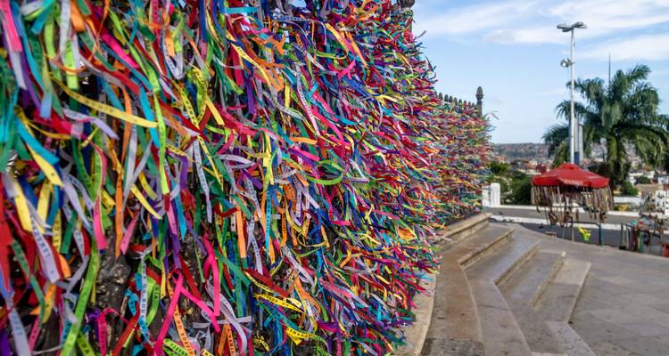 Bunte Gebetsbänder an einen Zaun gebunden.