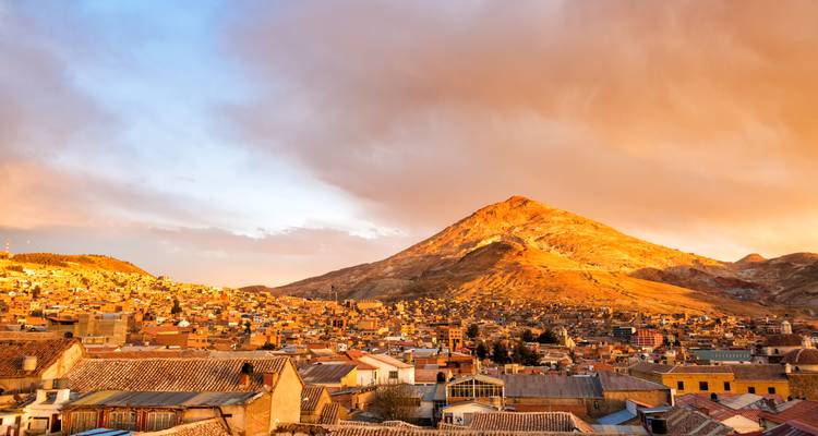 Stadt mit einem Berg, der im Licht des Sonnenuntergangs glüht.