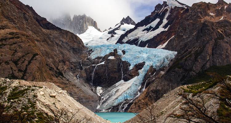 Glacier bleu se déversant dans un lagon turquoise encadré par des pics patagoniens imposants