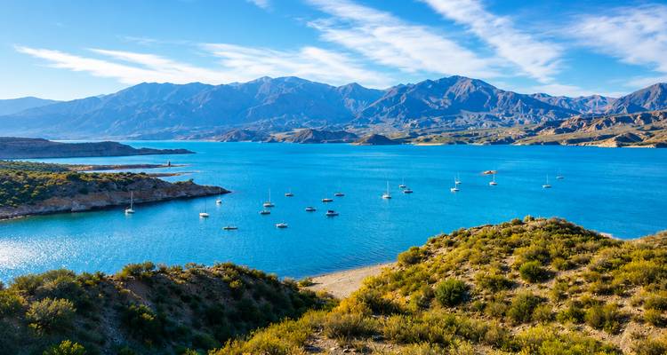 Embalse de un azul brillante salpicado de veleros con los Andes nevados de fondo cerca de Mendoza.