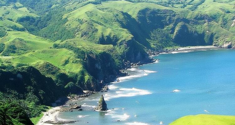 Paysage côtier avec falaises vertes et vagues océaniques.
