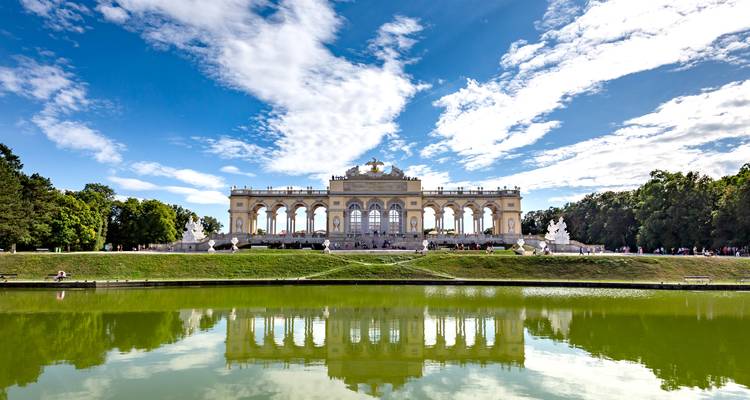 Le pavillon de la Gloriette dans les jardins de Schönbrunn à Vienne se reflétant dans un étang calme par une journée ensoleillée.