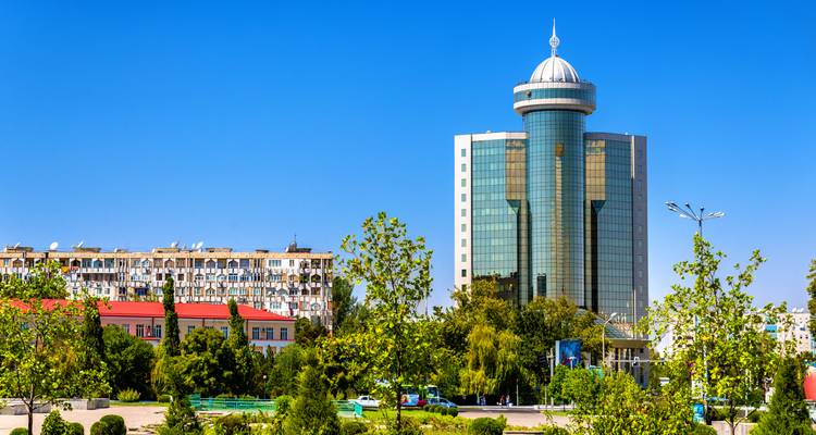 Modern skyscraper next to a residential building, with clear blue sky