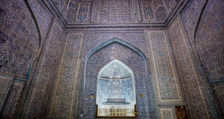 Chambre intérieure faiblement éclairée recouverte du sol au plafond de mosaïques bleues complexes