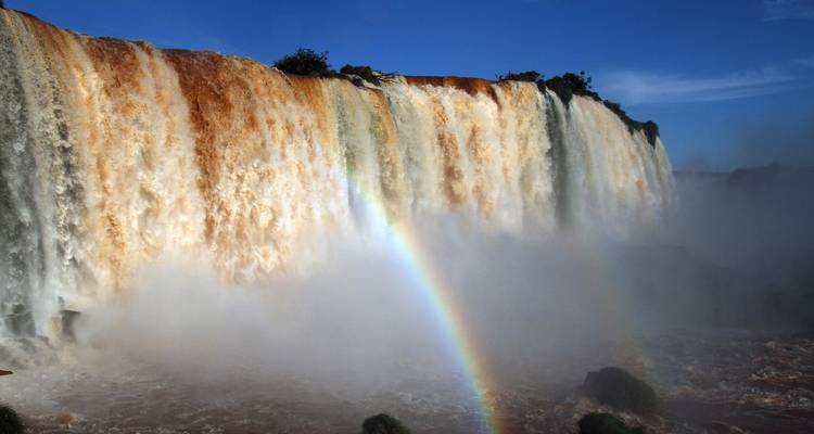 Cataratas del Iguazú con un arcoíris visible sobre el agua.