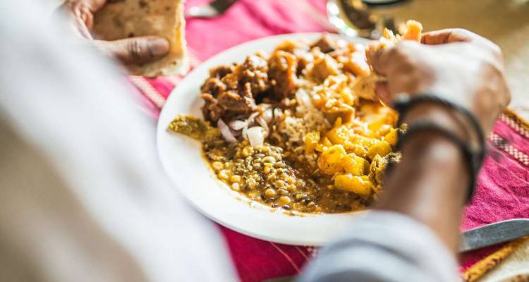 Gros plan d'une personne mangeant de la nourriture indienne traditionnelle.