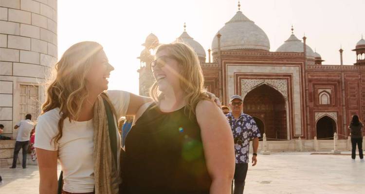 Deux personnes souriantes devant une architecture historique.