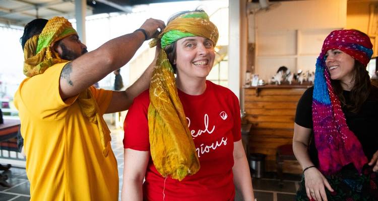 Des personnes essayant des foulards colorés à l'intérieur.
