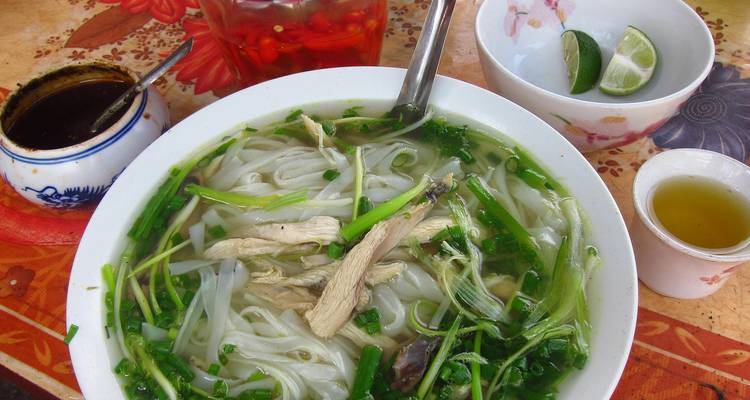 Plato tradicional vietnamita de pho con hierbas y condimentos.