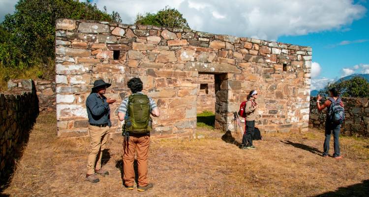 Turistas explorando ruinas hechas de ladrillos de piedra.