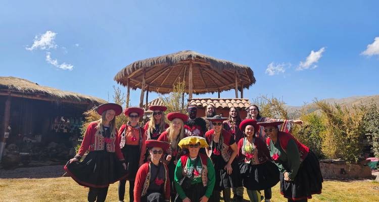Un groupe de personnes en tenue traditionnelle posant à l'extérieur.