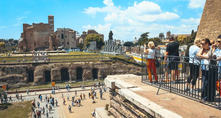 Blick vom Römischen Forum mit Menschen, die auf historische Ruinen blicken.