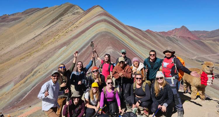 Groupe posant avec la Montagne Arc-en-ciel en arrière-plan.
