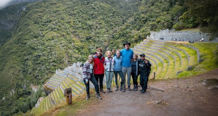 Gruppe von Wanderern, die auf einer Inka-Terrasse mit malerischer Kulisse stehen.