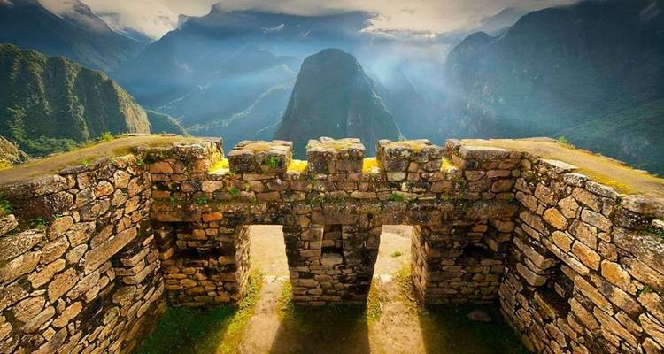 Malerische Aussicht von einer antiken Ruine mit Bergen und Sonnenstrahlen.