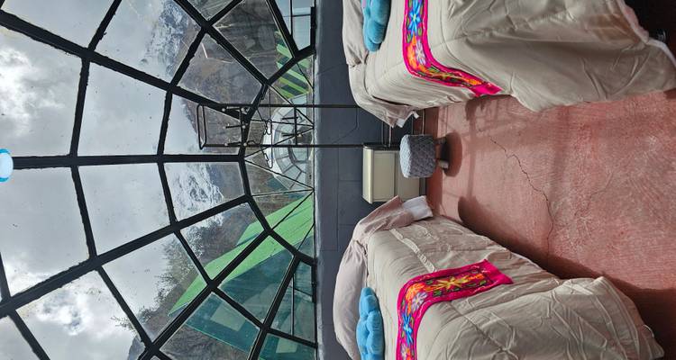 Innenraum einer einzigartigen Glaskuppel mit zwei Einzelbetten und Bergblick.