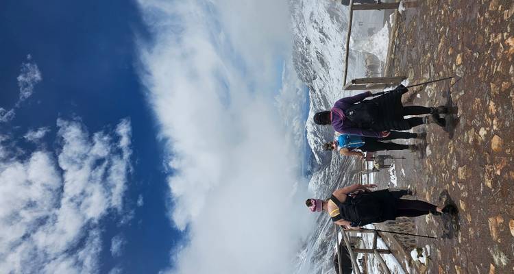 Wanderer, die einen verschneiten Bergpfad entlanggehen.