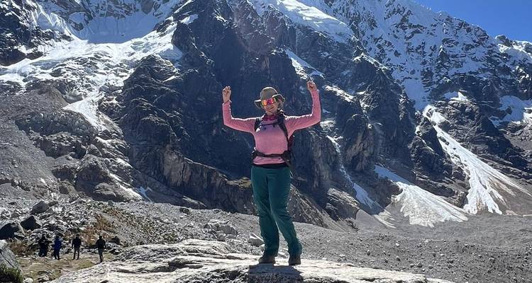 Person, die triumphierend vor einem schneebedeckten Berg posiert