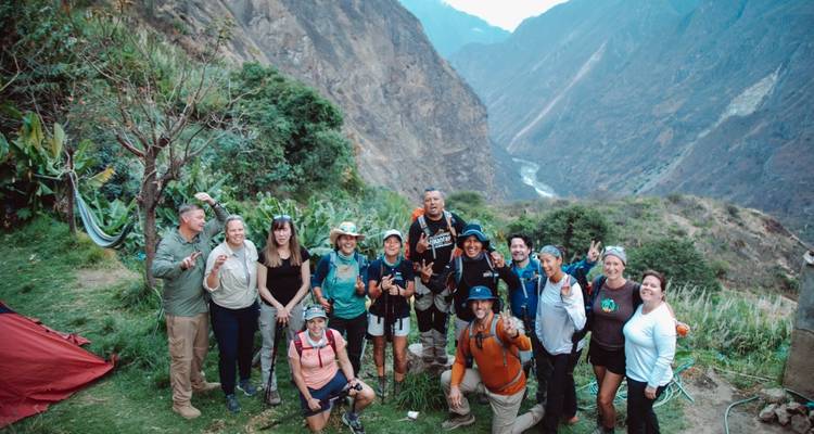 Gran grupo de excursionistas con fondo montañoso.