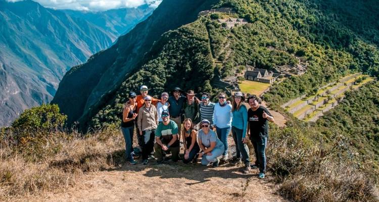 Groep poseert met Choquequirao ruïnes op de achtergrond.