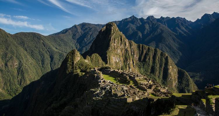 Vue aérienne des ruines de Machu Picchu sur fond de montagnes.