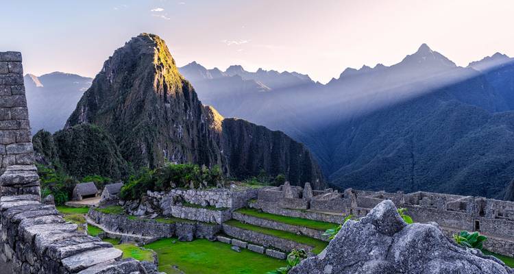 Machu Picchu dans la lumière du petit matin avec des ombres se projetant sur les structures.