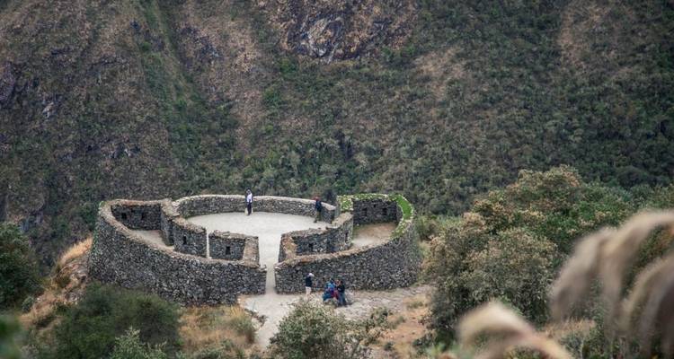 Estructura de piedra circular con personas en las ruinas de Runkuraqay.
