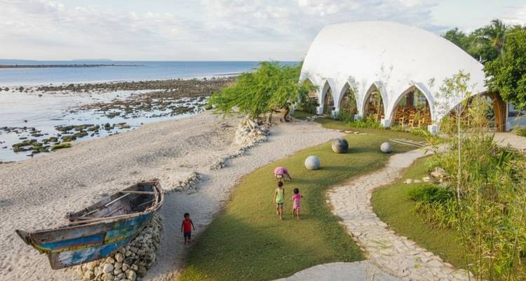 Seaside area with children playing and a unique dome structure.