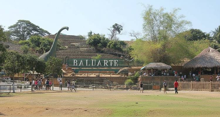Outdoor park with dinosaur installations and people visiting.