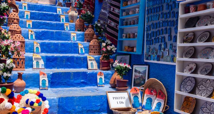 Felblauwe traptreden met kleurrijke aardewerk en souvenirs in de medina van Chefchaouen.