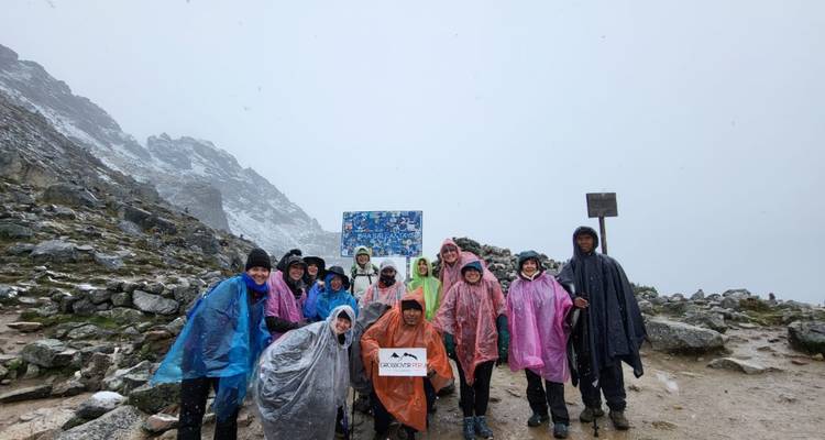 Groupe de randonneurs posant sur un col de montagne enneigé.