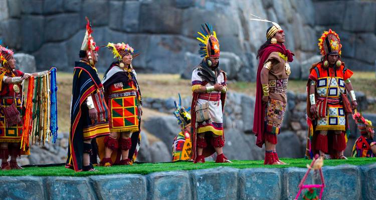 Défilé culturel avec des artistes en tenue traditionnelle sur une plateforme historique.