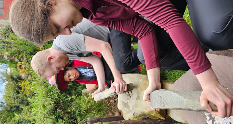 Toeristen die mais malen met traditionele methoden.