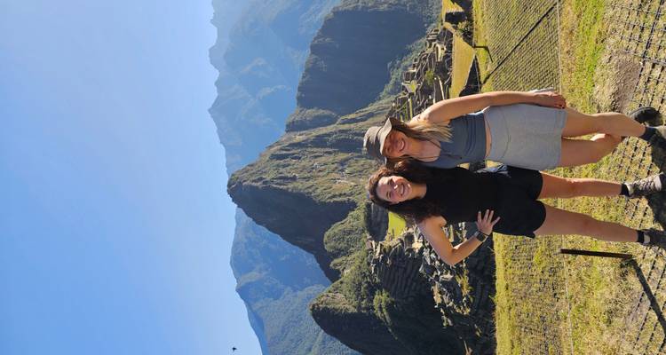 Twee vrouwen poseren met Machu Picchu op de achtergrond.