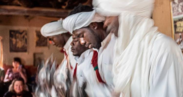 Image floue de mouvement de personnes en tenue traditionnelle.