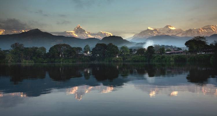Reflejos en un lago tranquilo con vistas a los montes Annapurna y Machhapuchhare.