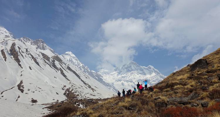 Excursionistas ascendiendo por un paisaje nevado en el Himalaya.