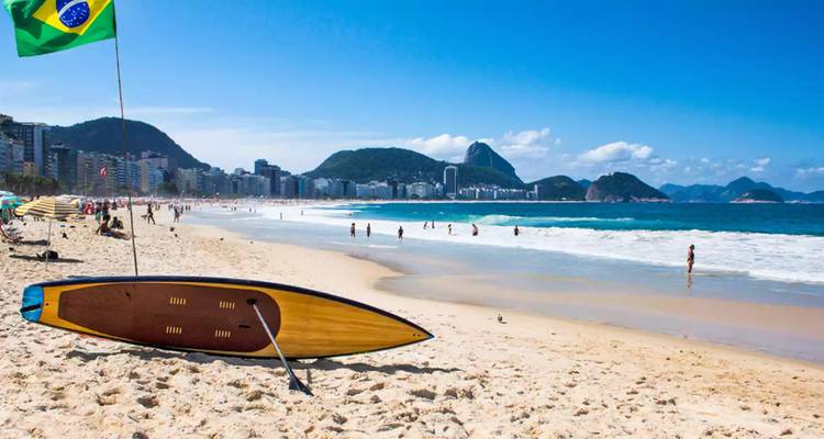 Planche de surf sur la plage de Copacabana avec un drapeau brésilien.