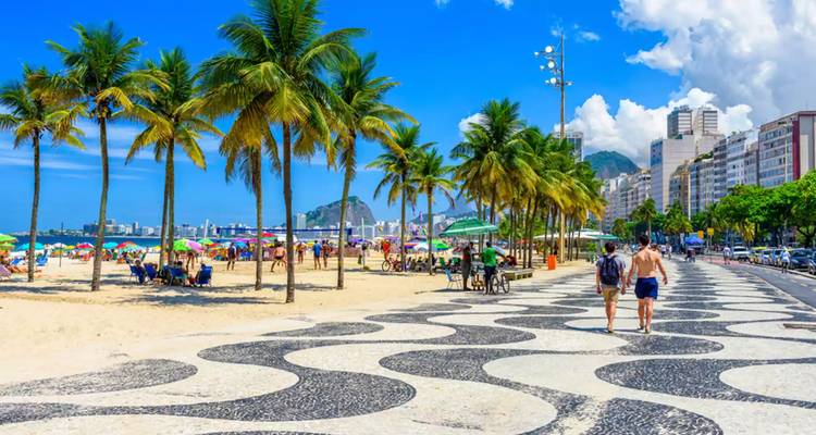 Scène de la plage de Copacabana avec des palmiers et des gens qui marchent.