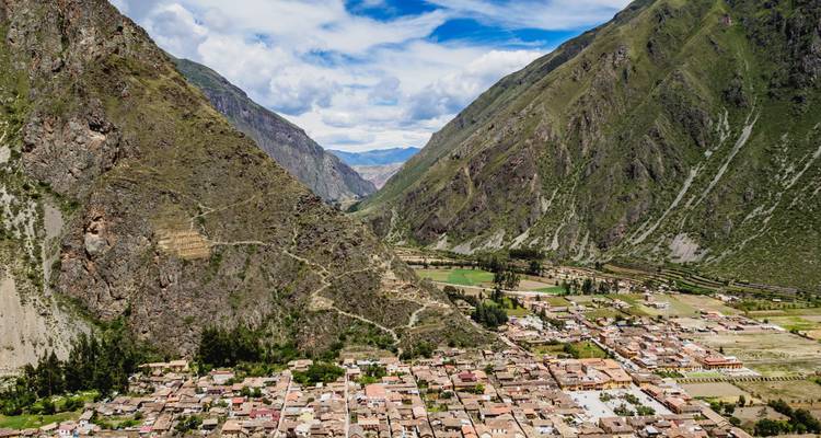 Pueblo enclavado entre montañas verdes escarpadas.