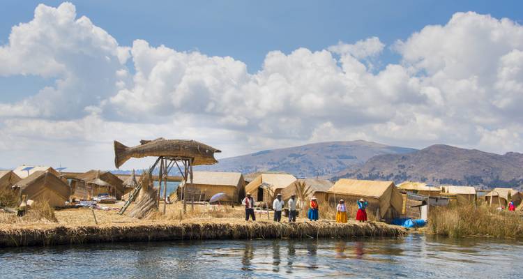 Islas flotantes de juncos con personas y una estructura de pez grande.