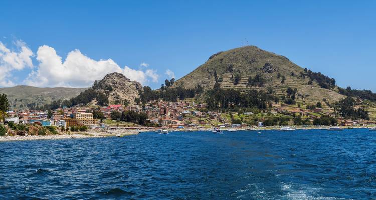 Ciudad costera con montañas al fondo.