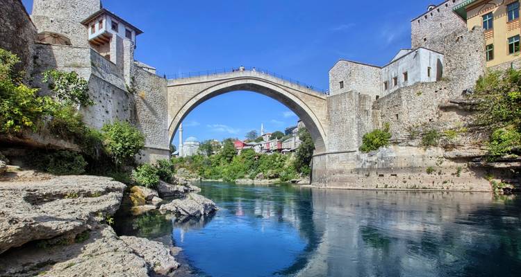 Historische Steinbogenbrücke, die einen Fluss überspannt.
