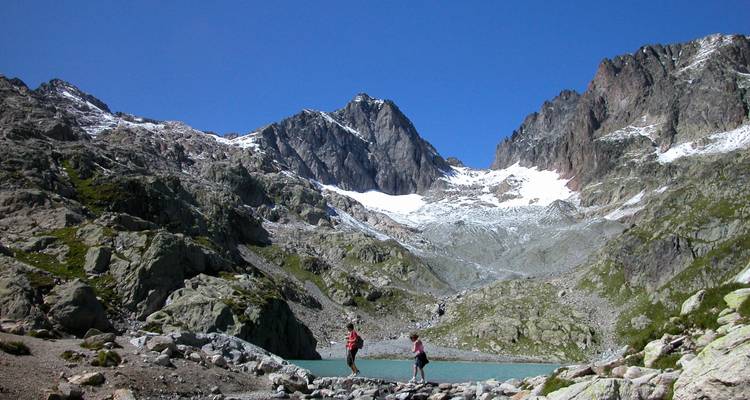 Randonneurs près d'un lac dans une région montagneuse.